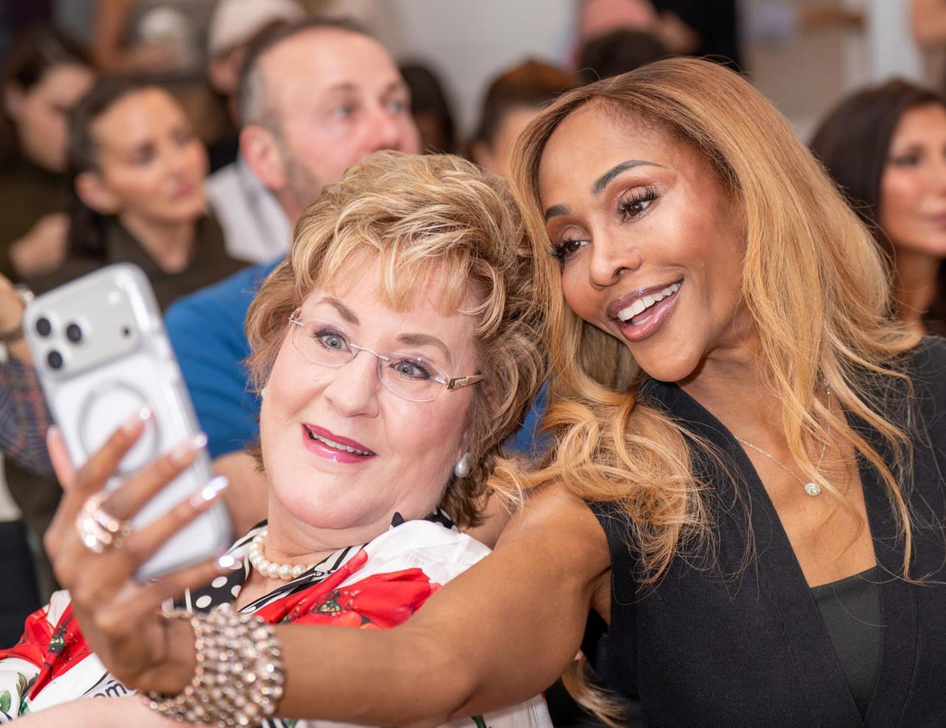 Zwei Frauen machen ein Selfie bei einer Abendveranstaltung