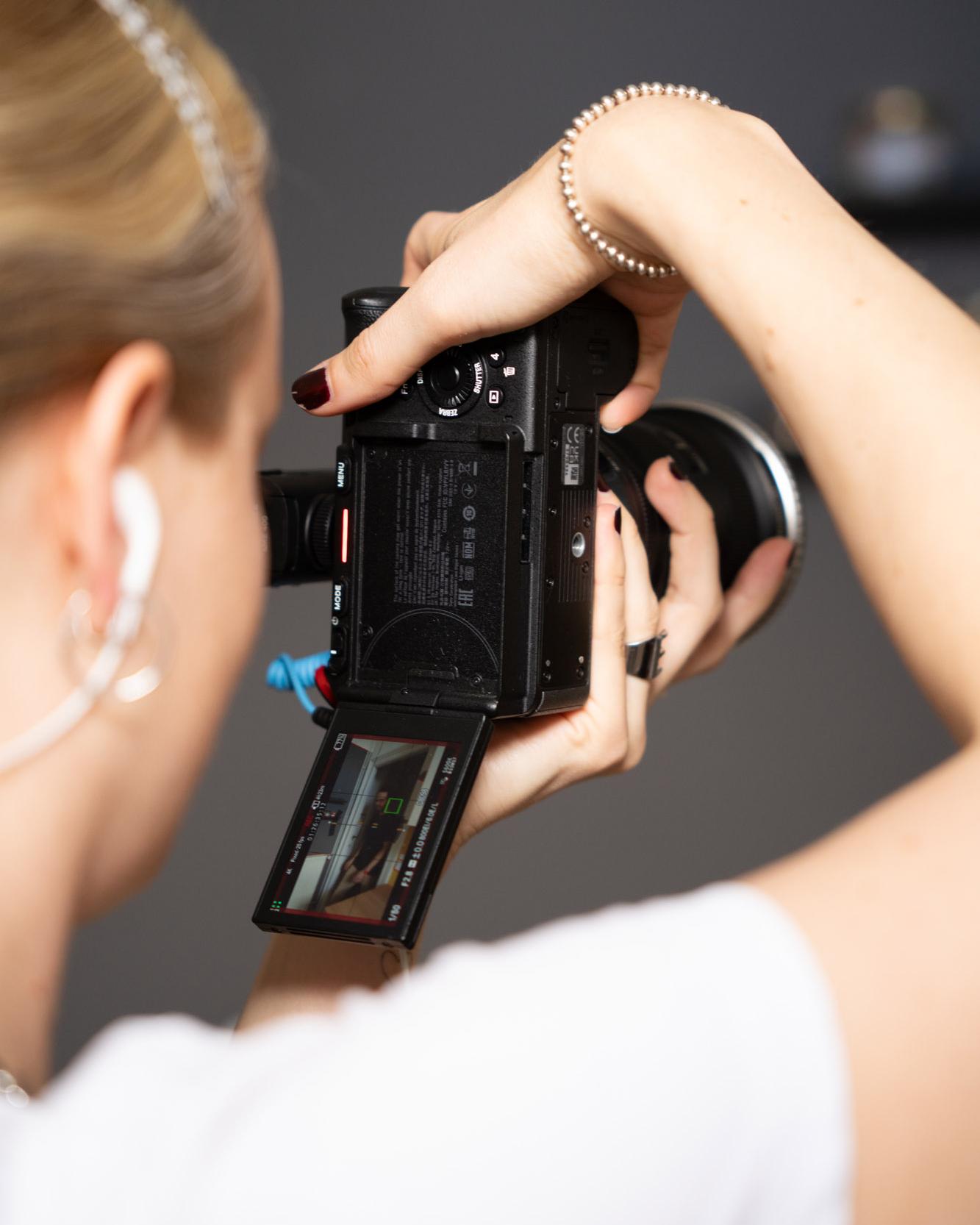 Hände halten eine Systemkamera beim Fotografieren