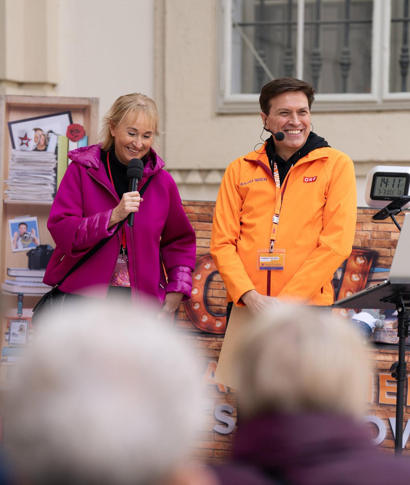 Zwei Frauen mit Mikrofon und Headset bei einer Moderation