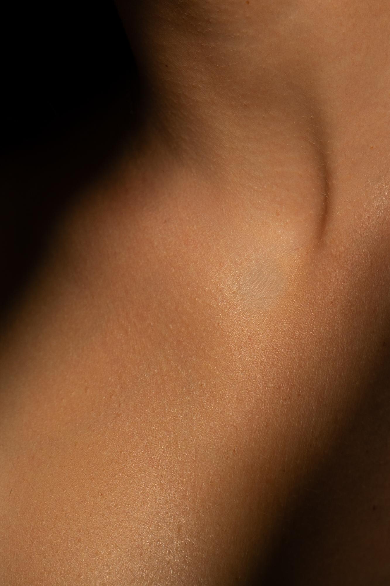 Detailaufnahme der Haut an Hals und Schlüsselbein im Streiflicht