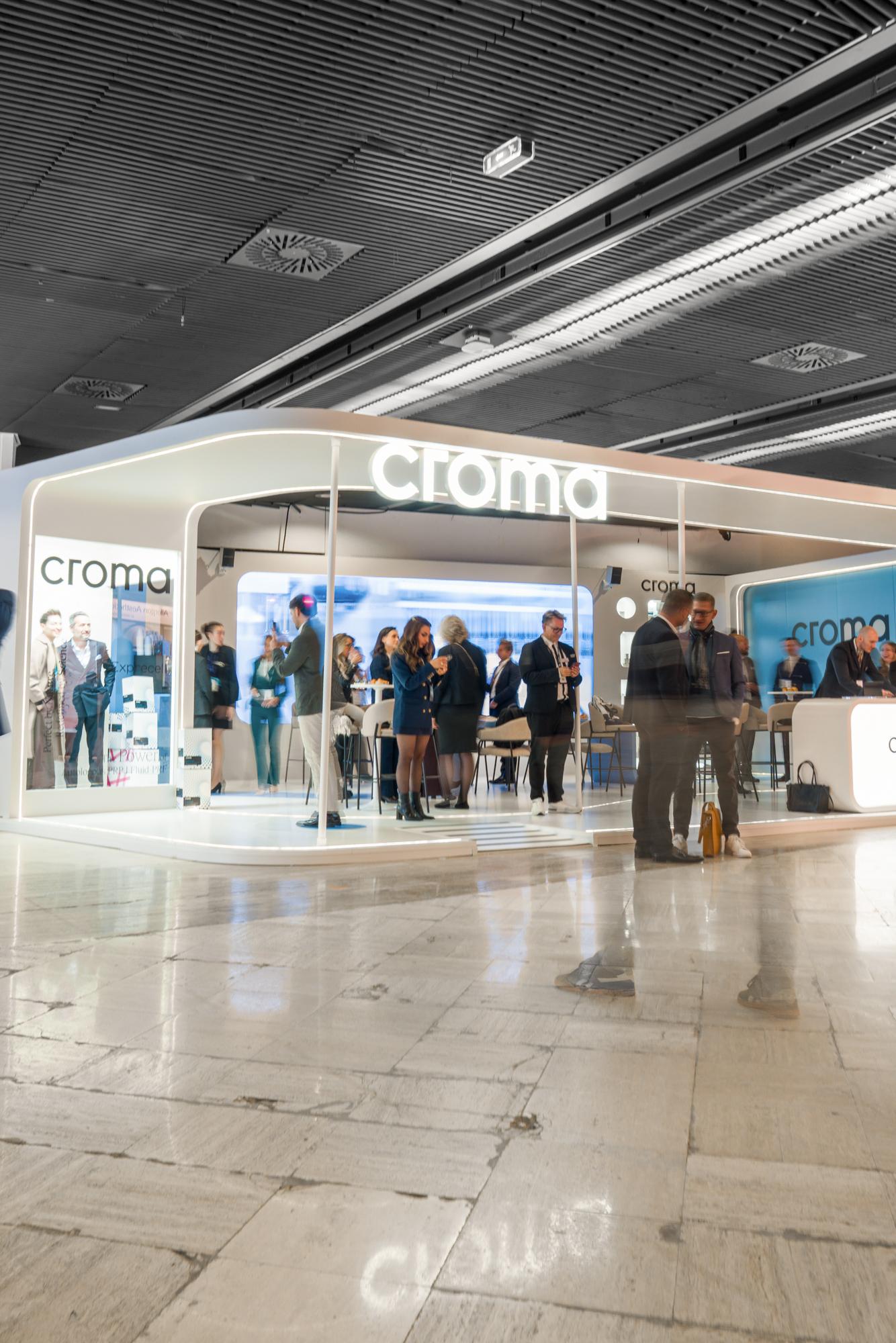 Messestand von Croma mit Besucherinnen und Besuchern in einer Kongresshalle