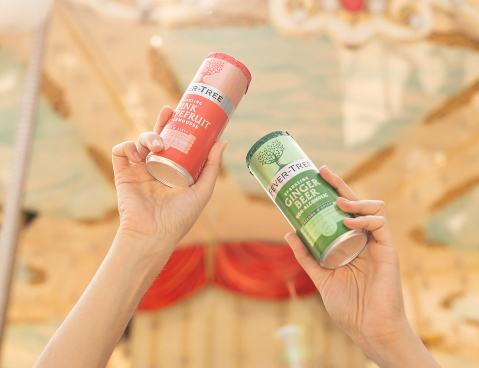 Zwei Hände halten Fever-Tree-Dosen vor verzierter Wand