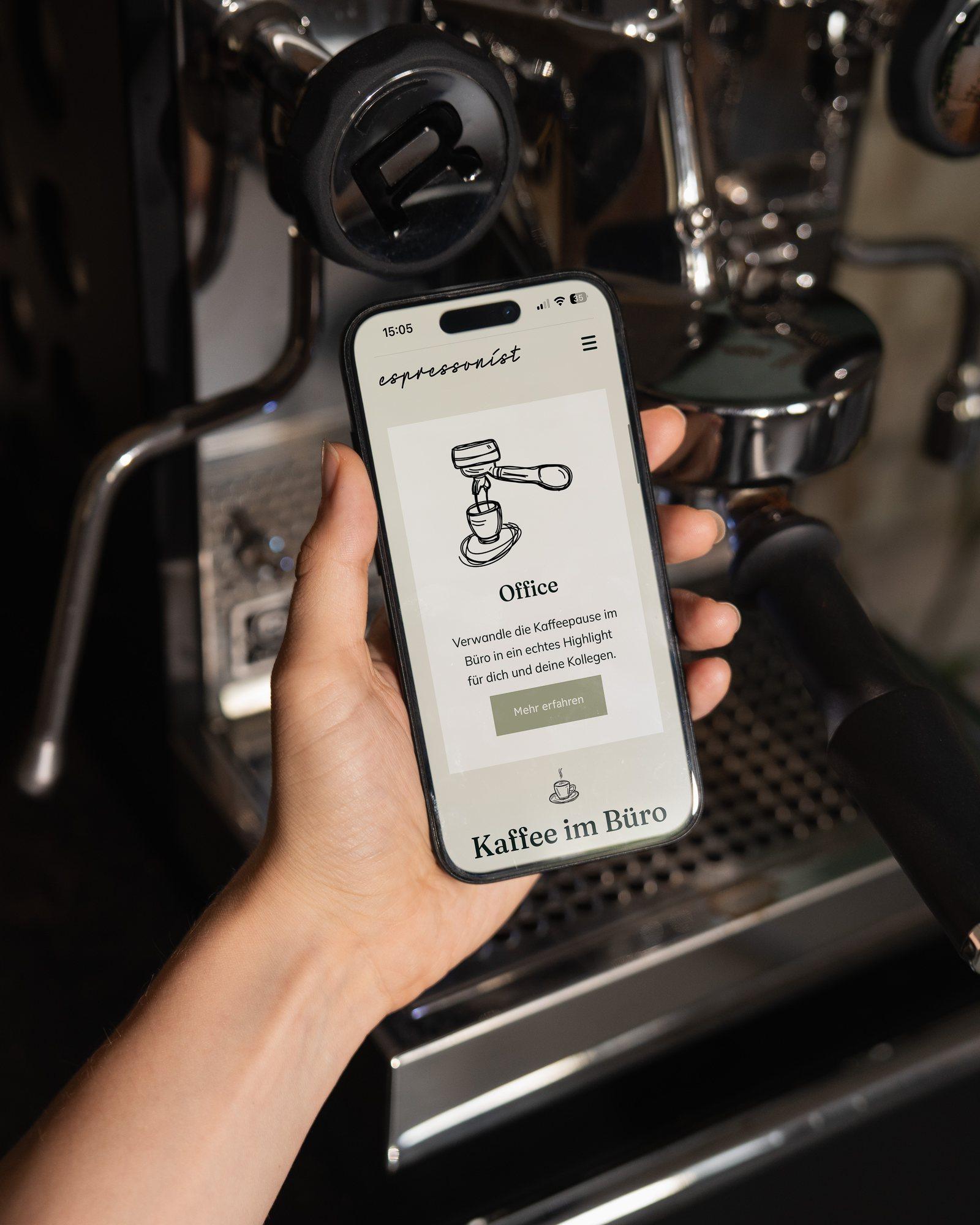 Smartphone mit der mobilen Website von espressonist vor einer Espressomaschine