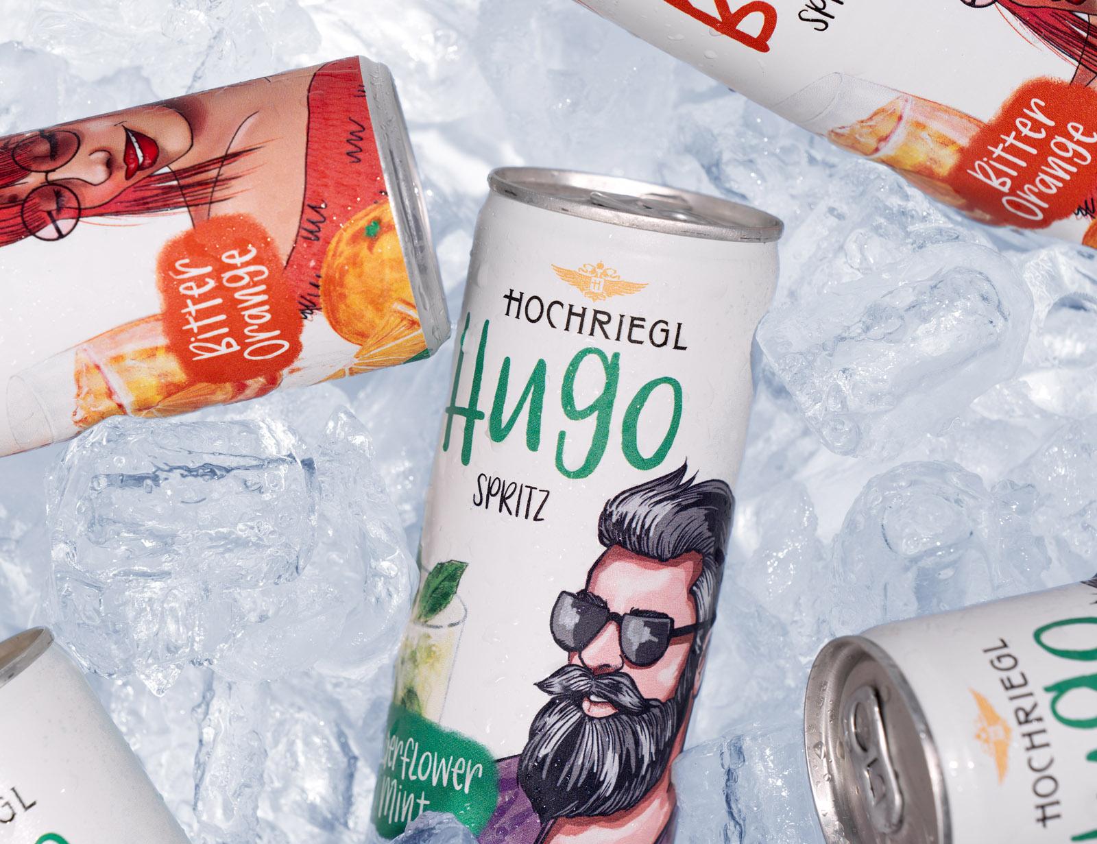 Hugo-Spritz-Dosen von Hochriegl auf Eis mit Fruchtverpackungen