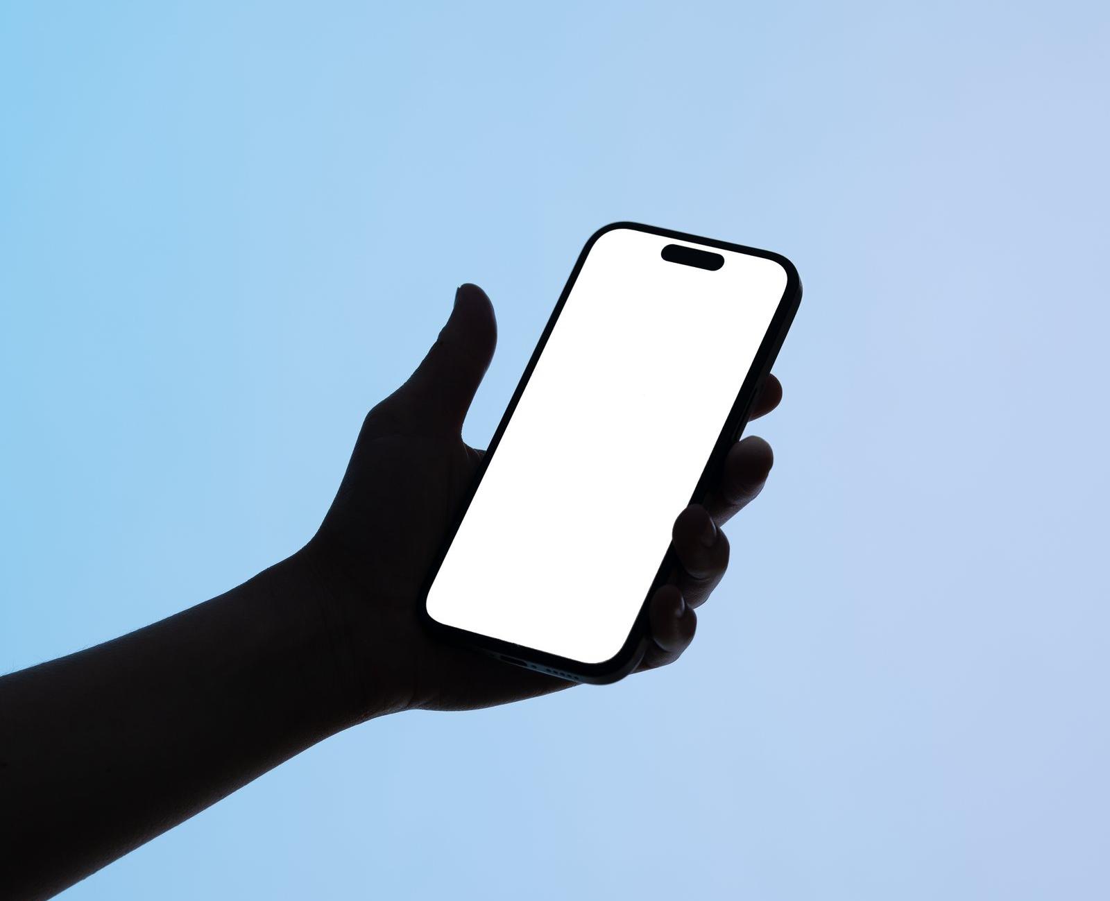 Smartphone-Mockup mit leerem Bildschirm vor blauem Hintergrund, in einer Hand gehalten