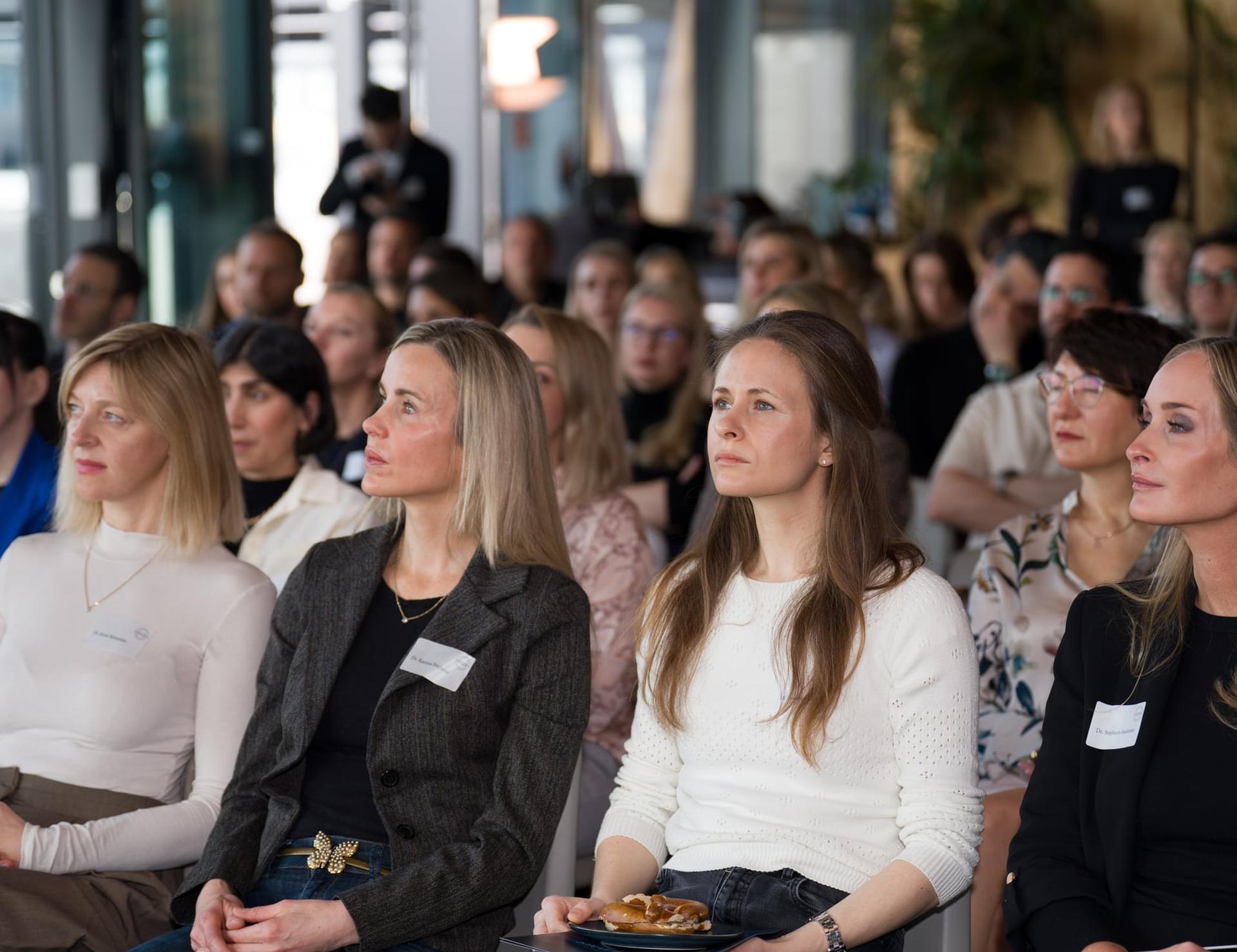 Publikum einer Fortbildungsveranstaltung in hellen Reihen