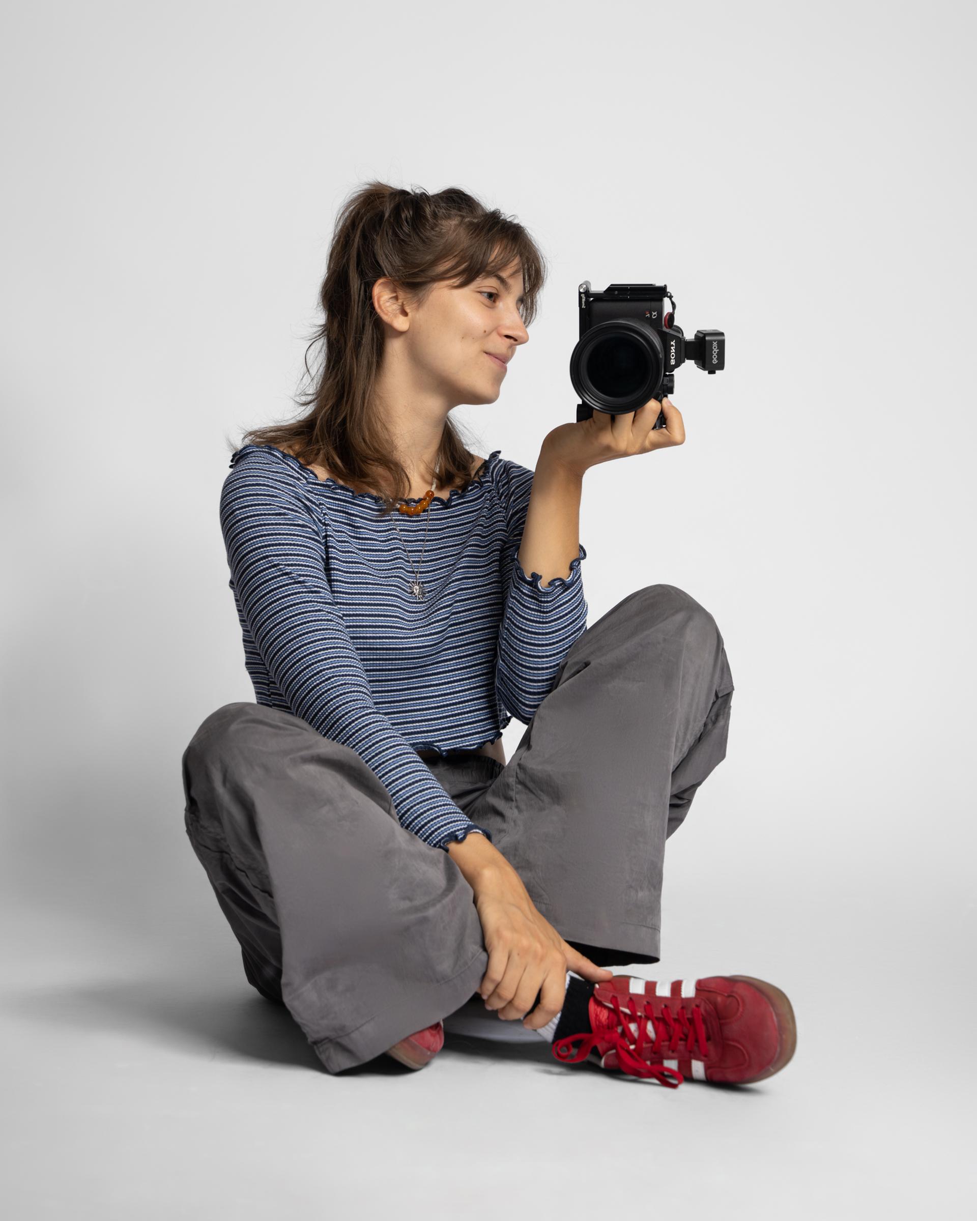 Verena Haitzinger sitzt mit einer Kamera in der Hand