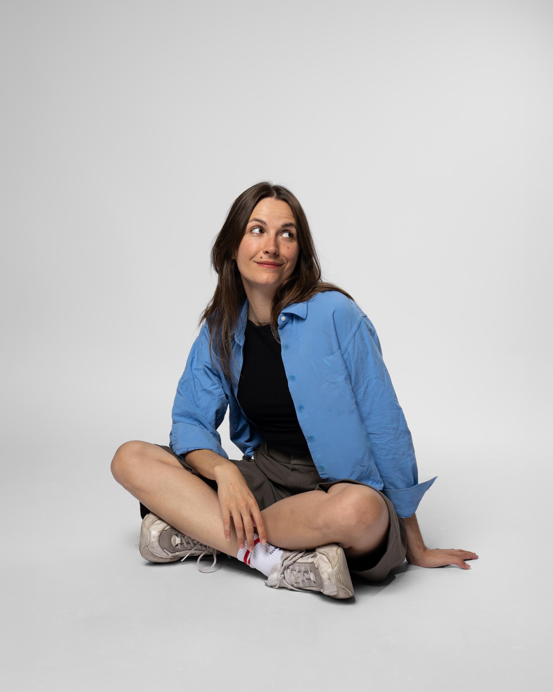 Mia Kordesch sitzt im Schneidersitz in blauer Jacke