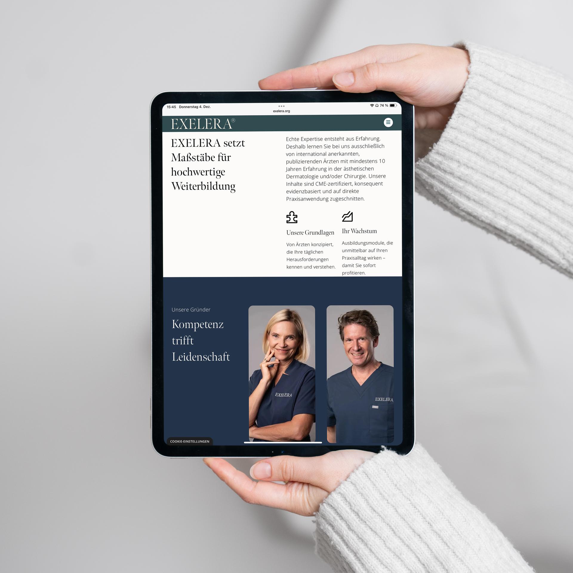 Smartphone zeigt die Exelera-Website mit zwei Ärztinnen