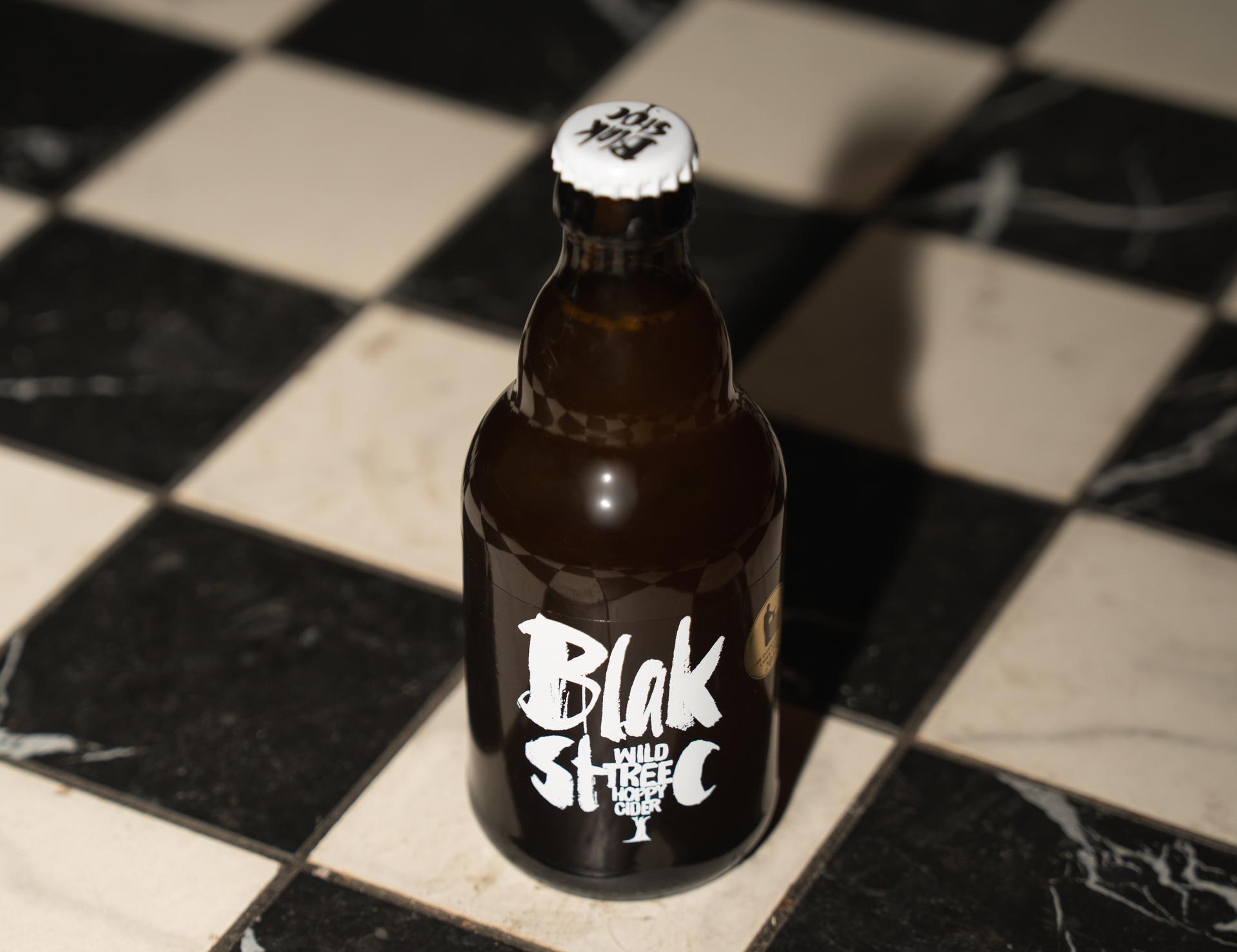 Bierflasche der Marke Blakstoc auf Schachbrettboden