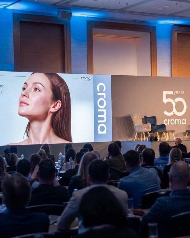 Croma Konferenz mit Präsentation auf zwei Leinwänden