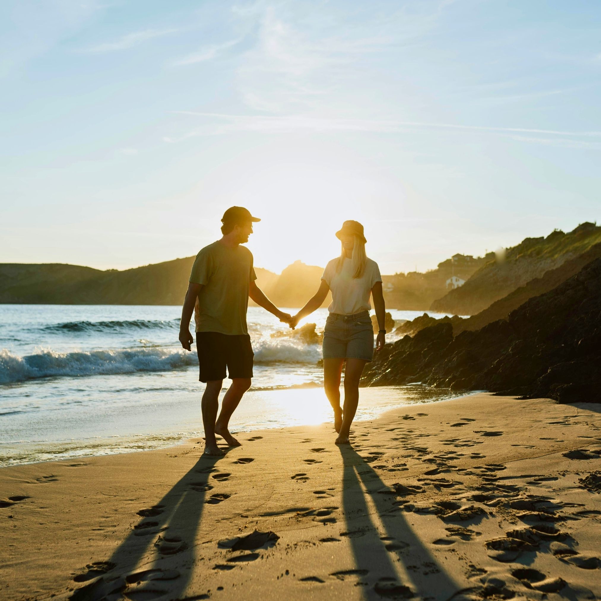 A couple spending time together on a beach on a bright day.
