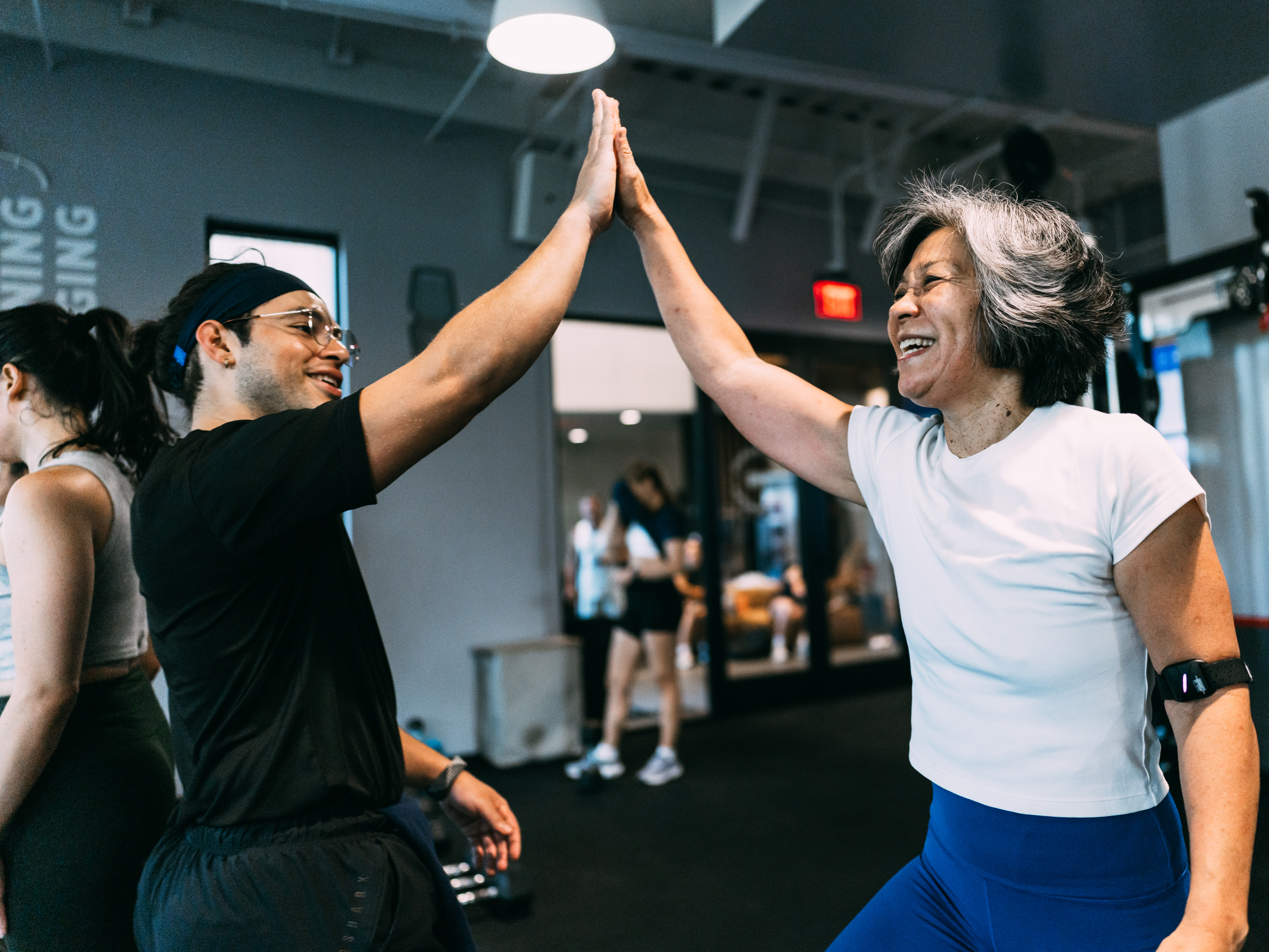 Man and woman doing a high five at a gym