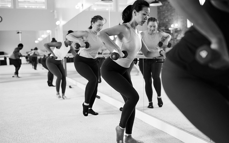 People participating in a group fitness class using dumbbells..