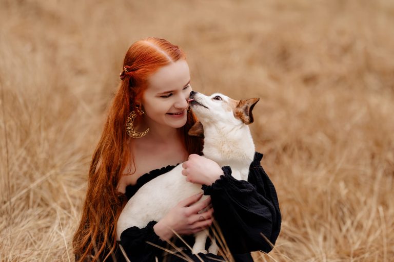 Rothaarige Frau schmust mit Jack Russell