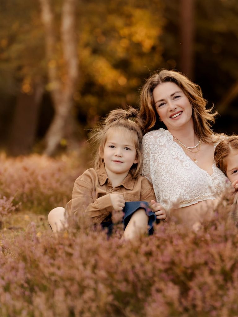 Mutter mit ihren Kindern in der Heide im goldenen Licht