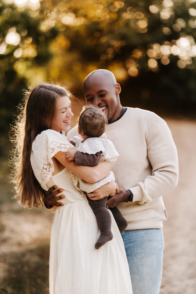 Familie lacht gemeinsam mit ihrem Baby