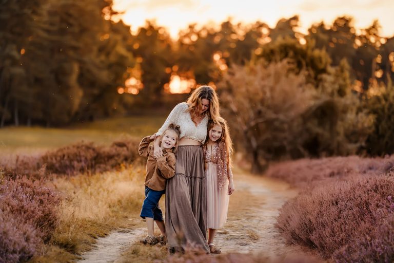 Familie auf einem Heideweg im Sonnenuntergang