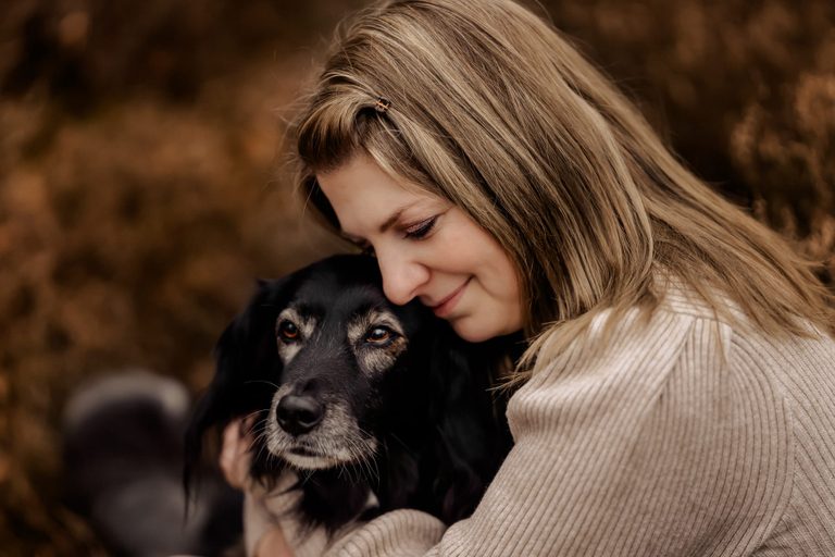 Frau umarmt ihren alten Hund innig