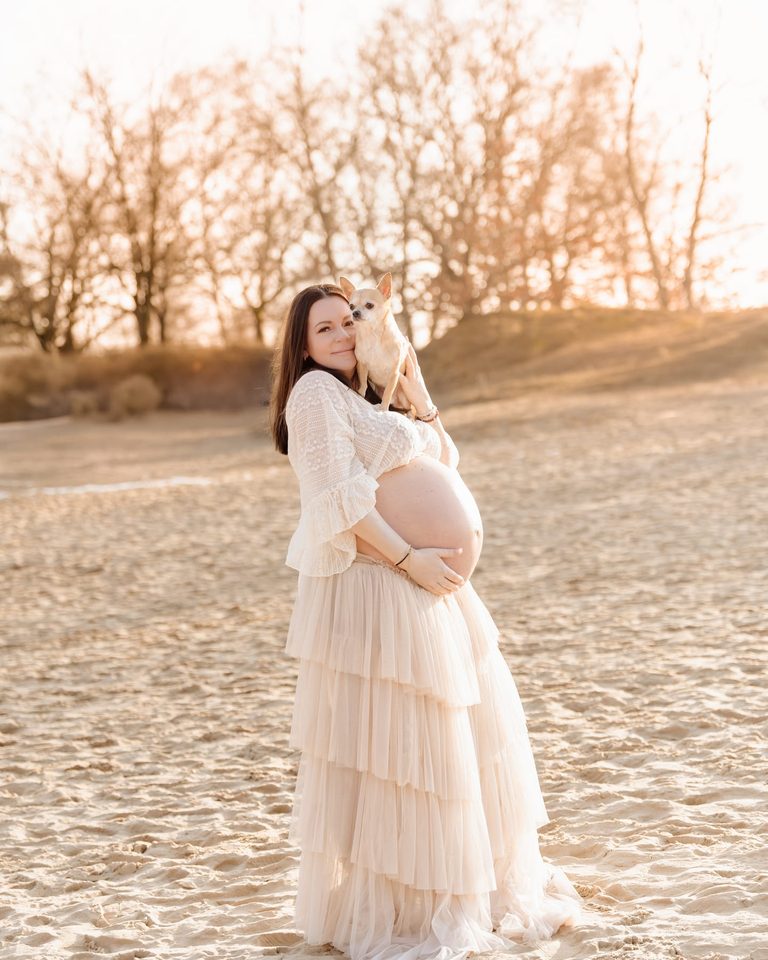 Schwangere im weißen Tüllkleid am Wasser