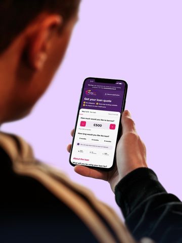 A hand holding a phone with an online form open on screen