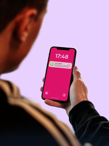 A hand holding a phone showing a notification on its lock screen