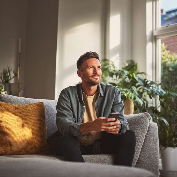 Man relaxing at home after sorting out an unexpected bill