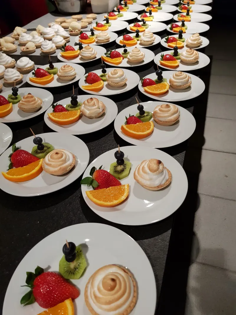 Reihen von Dessertteller mit Baiser-Tartelettes und frischem Obst