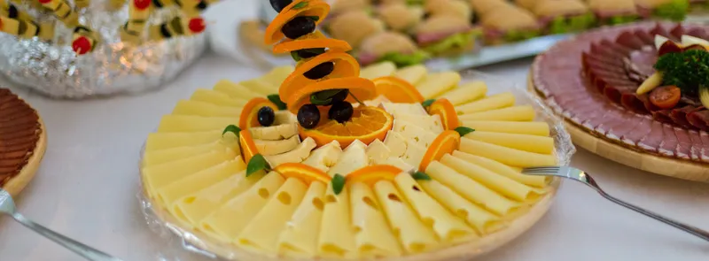 Dekorativ angerichtete Käse- und Wurstplatte mit Orangenspiralen