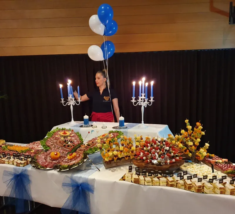 Reich dekoriertes Partybuffet mit Fleischplatten, Häppchen und Kerzenlicht