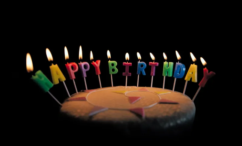Bunte «Happy Birthday»-Kerzen auf einer Geburtstagstorte