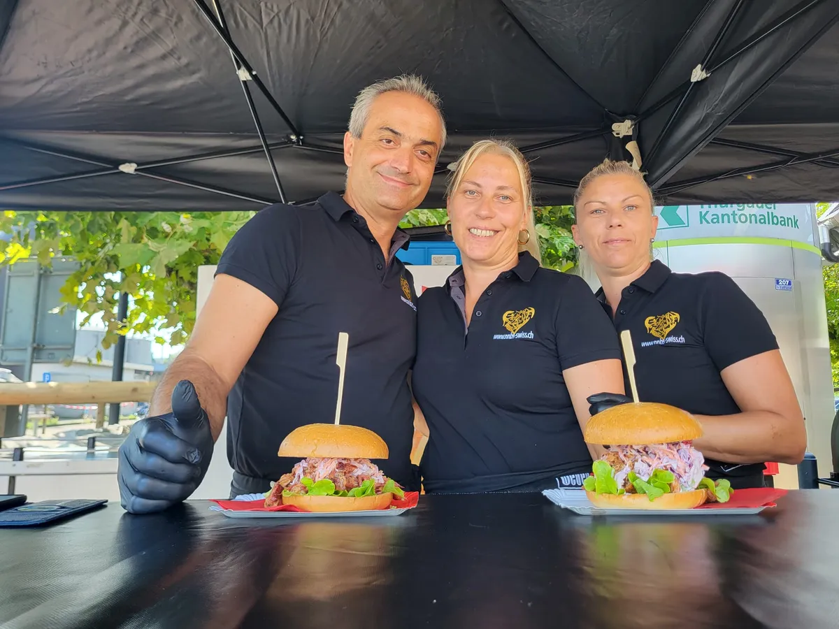 Das NNBS-Team präsentiert frisch zubereitete Burger an einem Streetfood-Stand