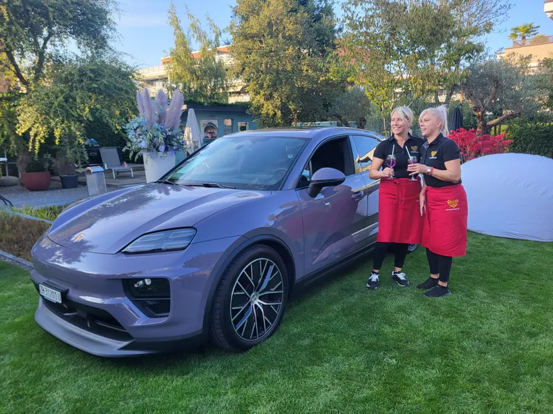 NNBS-Team serviert Drinks neben einem Porsche in einem Garten