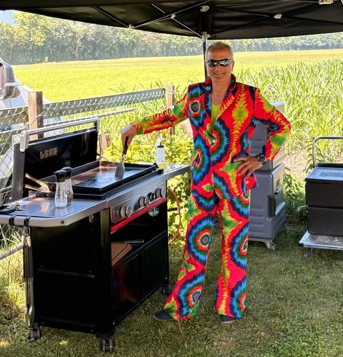 Grillkoch im bunten Kostüm an einer Motto-Party