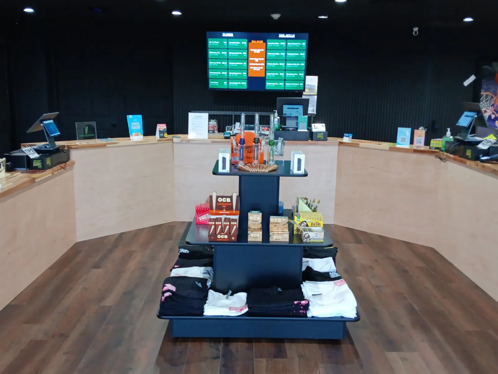 The Best Budz NJ sales floor: the wood counter, a display of papers and merch, and the menu screen