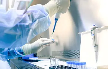 Laboratory professional using a pipette to transfer samples into reaction tubes during NGS library preparation, supporting adapter incorporation, amplification and sequencing-ready library construction workflows.