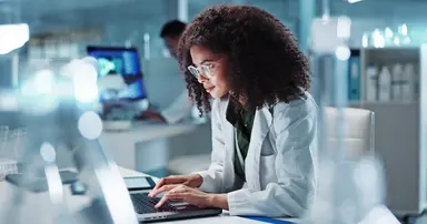Laboratory professional reviewing analytical performance data on a computer.