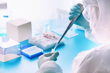 Laboratory sample testing with pipette and microplate.