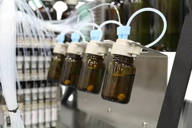 Automated oligonucleotide synthesis system with reagent bottles and fluidic connections used for DNA and RNA oligonucleotide manufacturing.