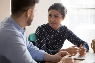 Two individuals discussing custom competent cell requirements and project specifications in a meeting.
