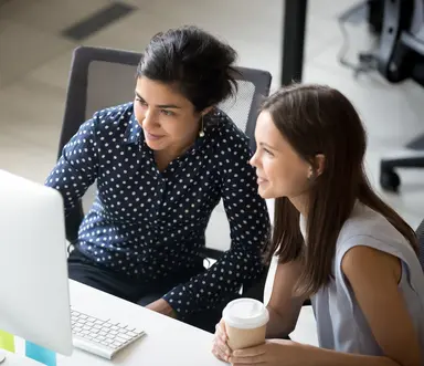 Team members reviewing information on a computer as part of a collaborative project planning and customer support workflows.
