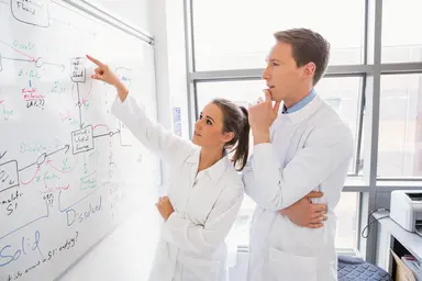 Laboratory professionals collaborating on a technical workflow review, representing customer partnership, product development and validation support for diagnostic testing applications.