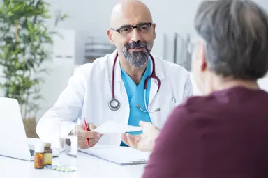 Healthcare professional reviewing medical information with a patient during a consultation, representing the importance of diagnostic accuracy, quality healthcare decision-making and reducing diagnostic errors.