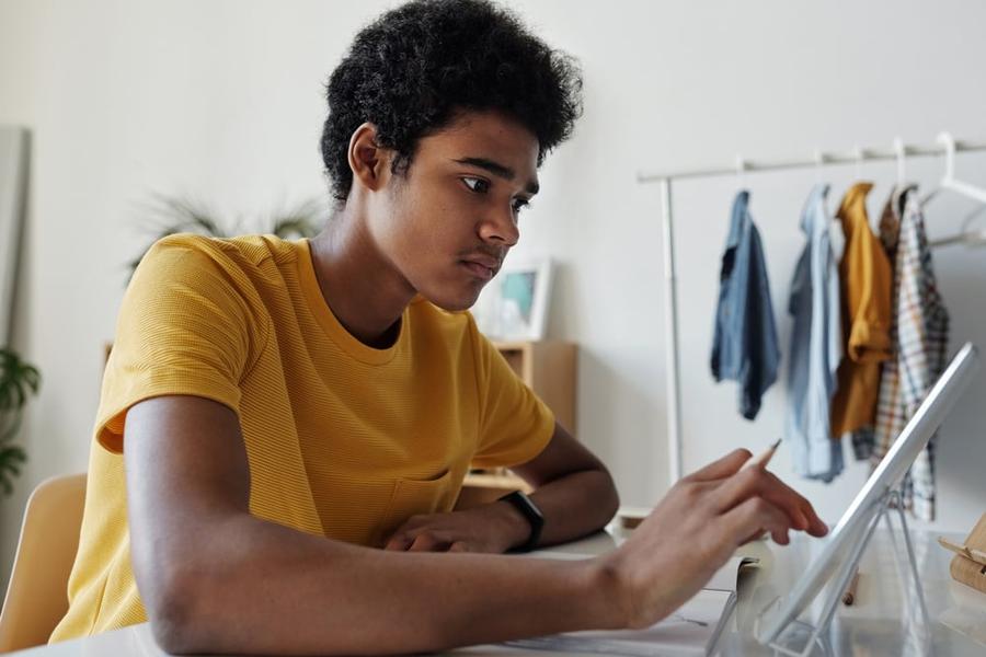 A writer works on a tablet at a desk.