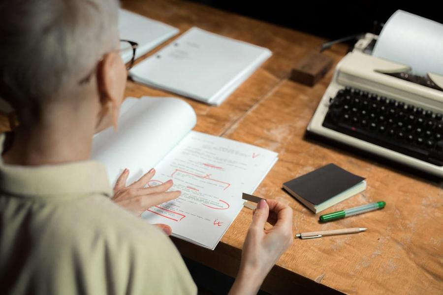 Over-the-shoulder view of a screenwriter editing a screenplay.