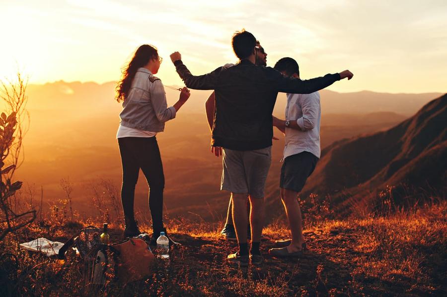 Teenagers hang out on an overlook at sunset.