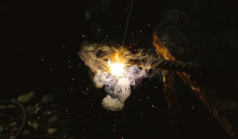 A piece of iron with bright white sparks on one end.