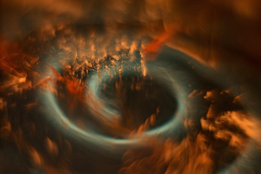 A swirl of orange and blue dust against the dark sky.