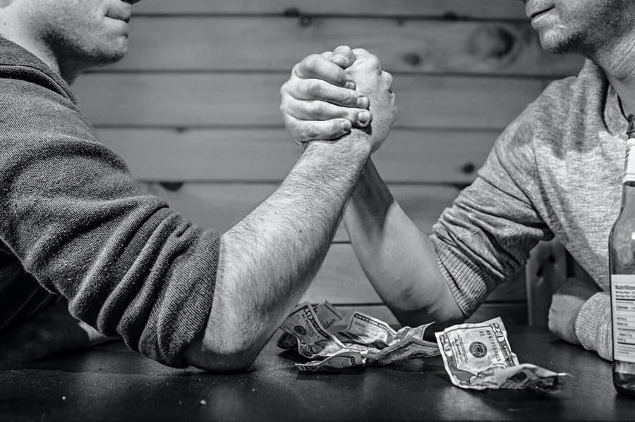 Black and White Photo of Two Muscular Arms Arm Wrestling