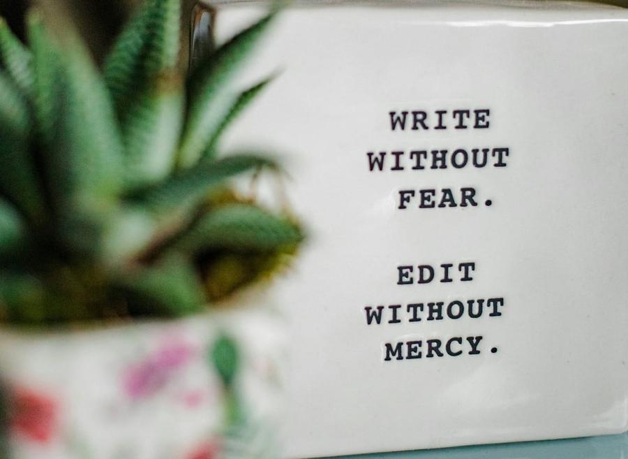 Decorative white block with black text saying: write without fear, edit without mercy.